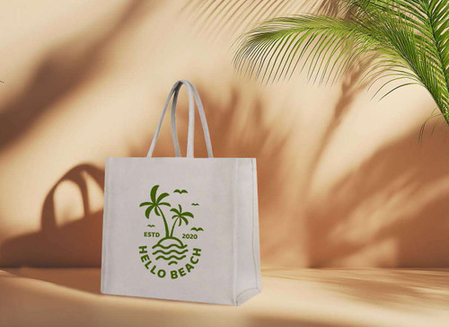 A light canvas bag featuring green palm tree graphics and a logo, set against a warm, minimalist background.