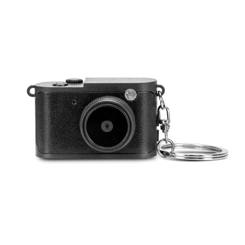 A mini camera in black with a textured finish and a keychain attachment. It features a round lens and a control dial.