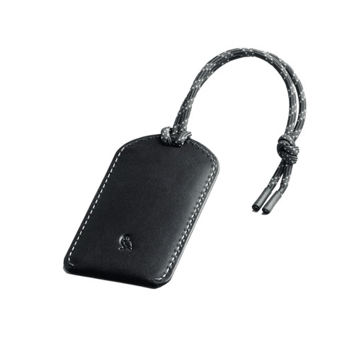 A black leather luggage tag with a grey braided cord and stitching detail, featuring a small logo.