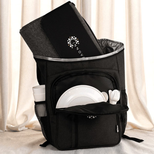 A black picnic backpack with a grey blanket, plates, cutlery, and a drink bottle in external pockets.
