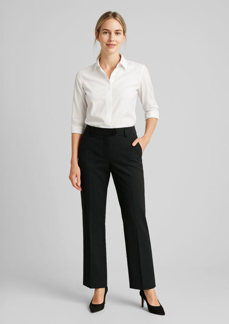 Black wool stretch adjustable waist pants paired with a white button-up shirt and high heels. The model stands with one hand in a pocket. Black wool stretch adjustable waist pants paired with a white button-up shirt and high heels. The model stands with one hand in a pocket.
