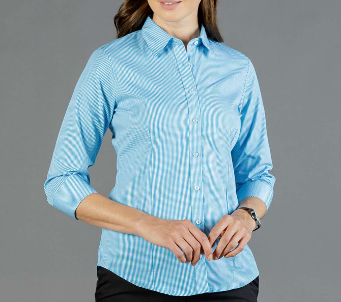 A button-up shirt in light blue gingham with long sleeves and a fitted design. The shirt has a logo on it.