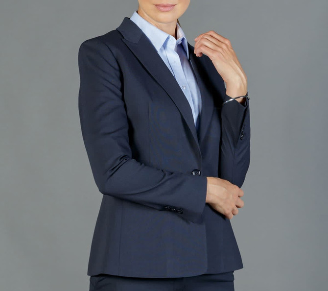 A navy Elliot Blazer displayed on a person, featuring a slim fit and tailored design, with a light blue shirt underneath.