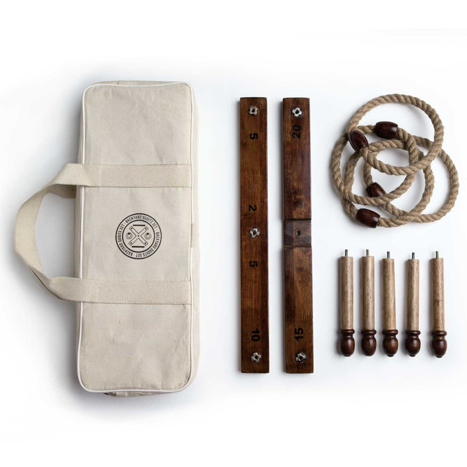 A Backyard Quoits Set featuring wooden quoits, ropes, and scoring boards in a cream carry case.