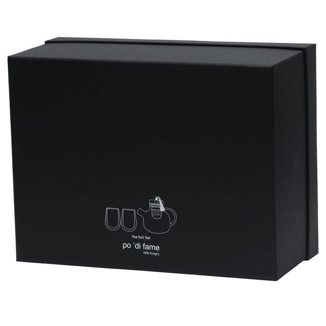 A black box contains a tea set, including a teapot and two cups, with a logo on the front.