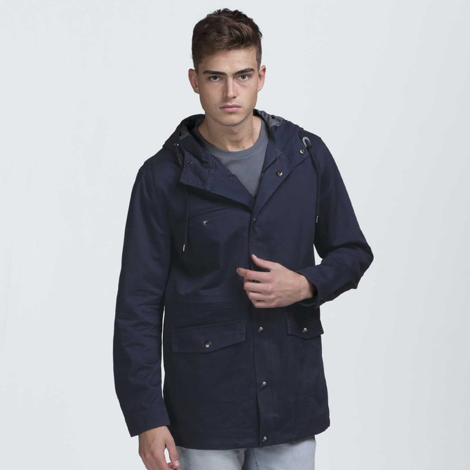 A navy blue jacket with a hood and multiple pockets, featuring a logo. Modelled by a young man. A navy blue jacket with a hood and multiple pockets, featuring a logo. Modelled by a young man.