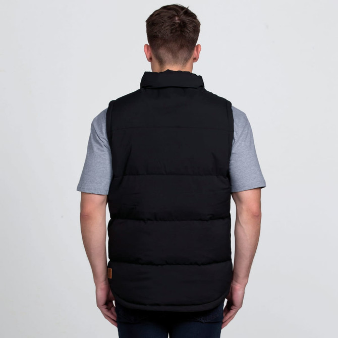 A black puffa vest with a high collar, viewed from the back, worn over a grey t-shirt. Features a logo.