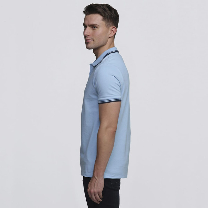 A light blue polo shirt with a contrasting collar and a branding logo. The shirt is worn by a model in profile.