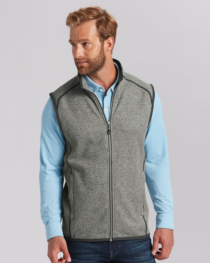 A grey men's vest with a zip front, featuring a high collar and contrasting trim, worn over a light blue shirt. A grey men's vest with a zip front, featuring a high collar and contrasting trim, worn over a light blue shirt.