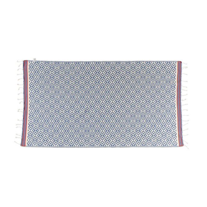 A blue and white patterned beach towel with fringed edges and a red stripe. Features a logo in one corner.