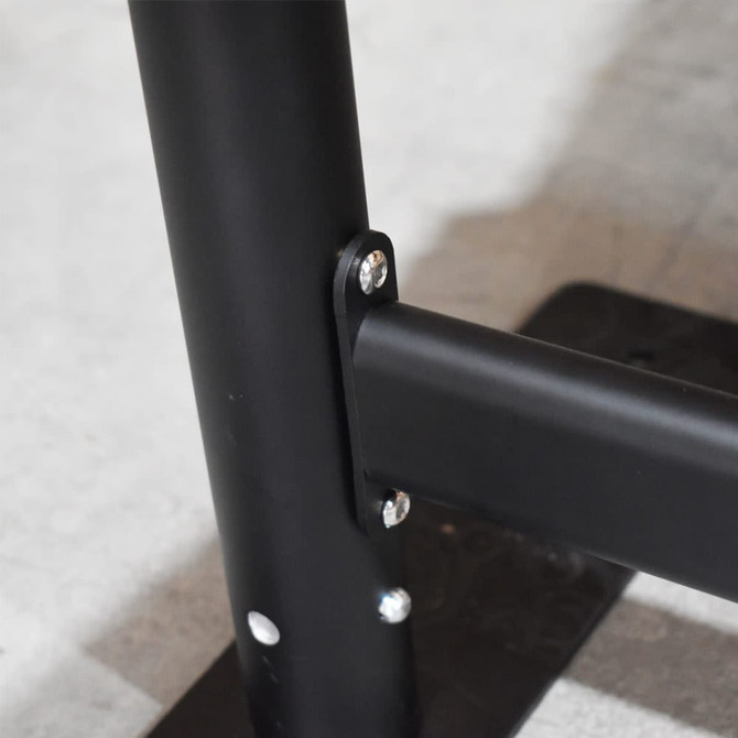 A close-up of a black metal crowd control barrier, featuring bolts and a sturdy base.