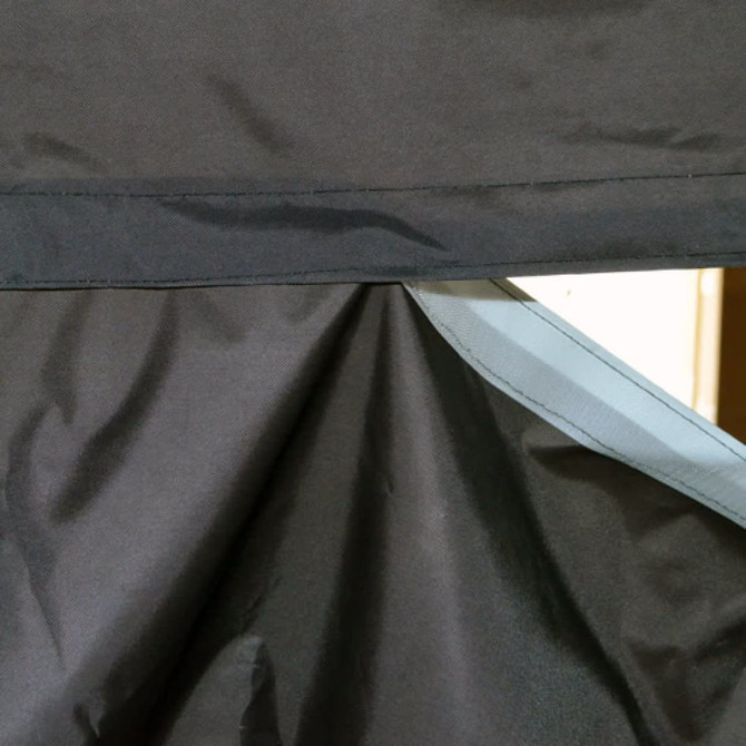 A close-up of a black fabric with a grey trim, showing the stitching and texture details of the material.