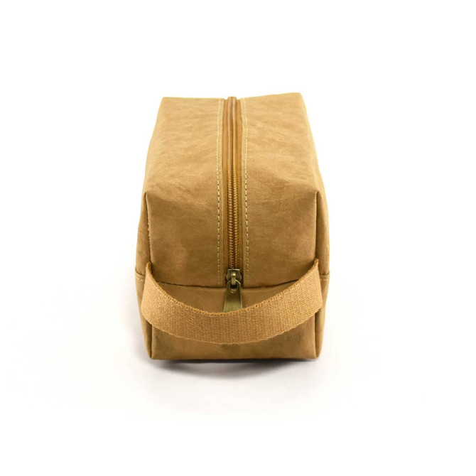 A tan Kraft paper cosmetic bag with a zip closure and a fabric handle on the side.
