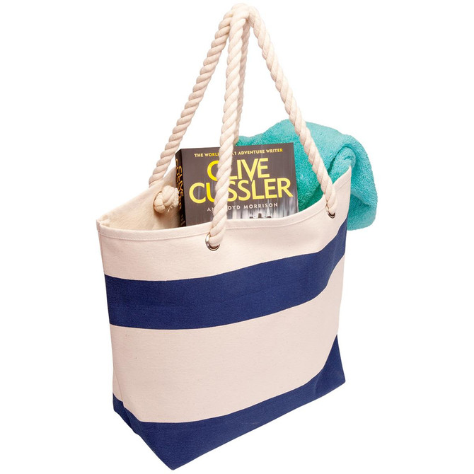 A cotton canvas tote in cream and navy, featuring rope handles, holding a book and a towel.