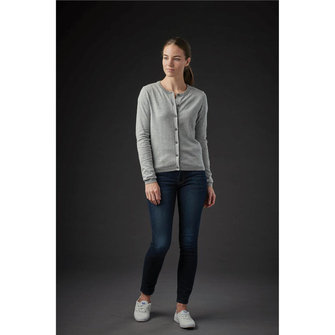 A grey women's cardigan with a button-up front, worn over dark jeans, set against a dark background.