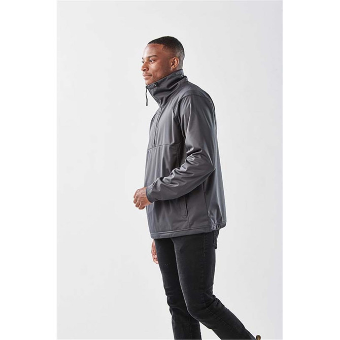 A man wearing a grey anorak jacket with a high collar and a front pocket, standing against a plain background.