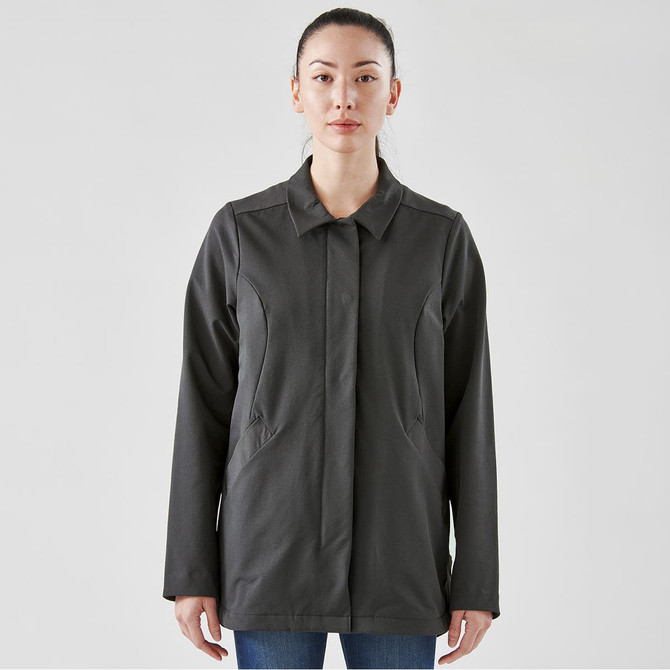 A woman wears a dark grey, long-sleeved Soho jacket with a collar and pockets, featuring a logo.
