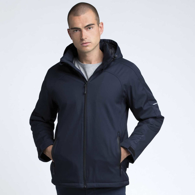 A model wearing a navy blue soft shell jacket with a hood, featuring a branded logo on the sleeve.