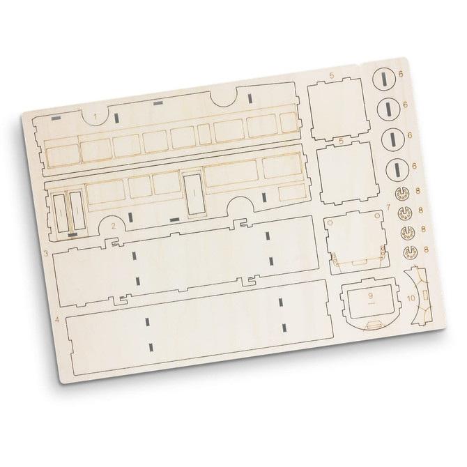 A wooden model kit for a bus, featuring cut-out sections on a light wooden board. Includes various pieces for assembly.