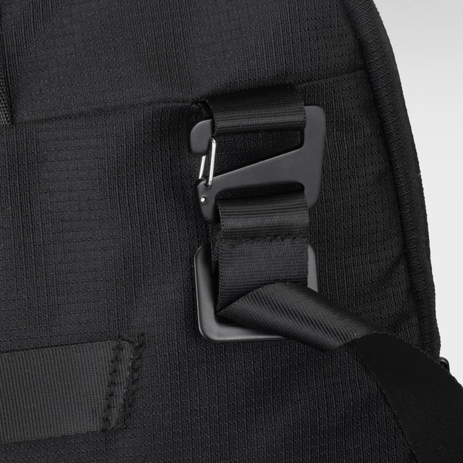 A close-up of a black computer bag showing a clip and straps, highlighting its adjustable features.