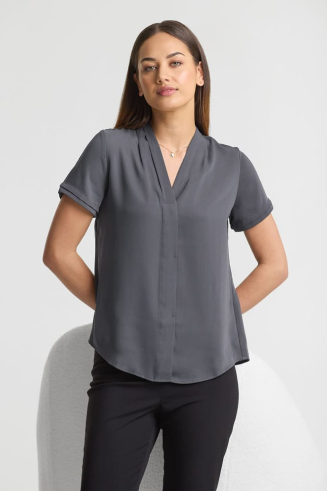 A grey short sleeve button-up shirt with a relaxed fit and a v-neck design, featuring rolled sleeves.