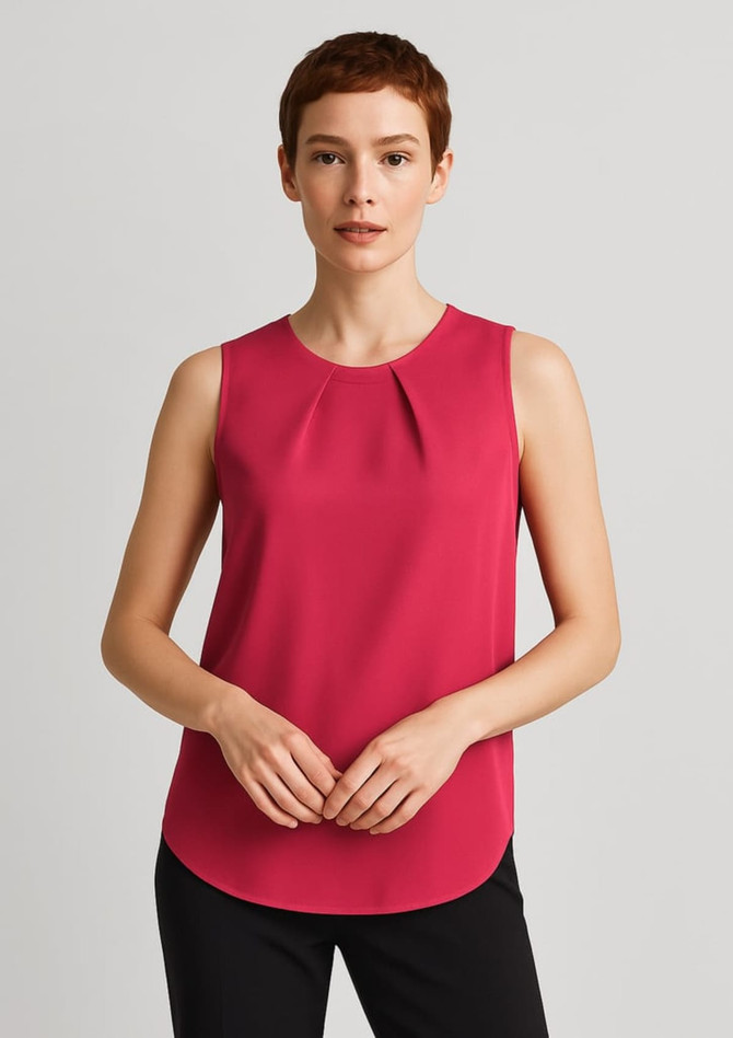 A sleeveless blouse in a rich pink colour featuring pleat detail at the front, modelled by a woman.