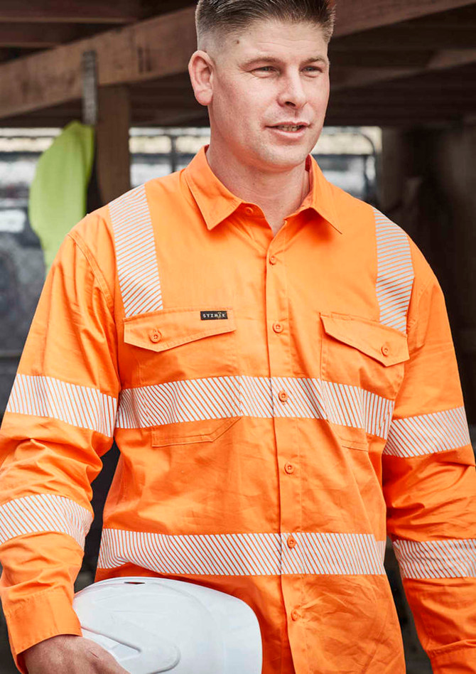 An orange long-sleeve work shirt with segmented reflective tape and a logo, worn by a man holding a white hard hat.