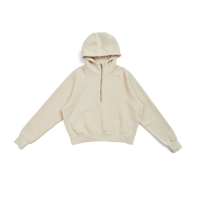 A cream half-zip jumper with a hood, featuring a relaxed fit and a ribbed waistband. Includes a logo.