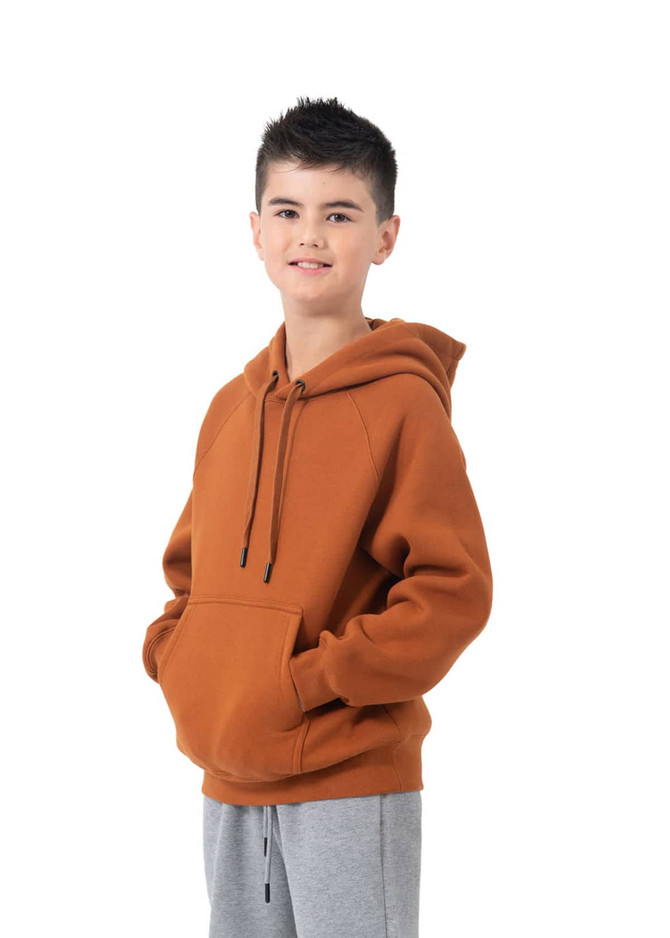 A hooded jumper in burnt orange colour featuring a kangaroo pocket and a logo. Worn with grey trousers.