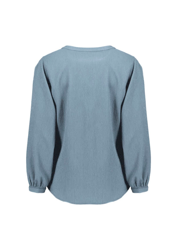 A women's long sleeve blouse in light blue, featuring a ruché design and a relaxed fit. It has a logo on the back. A women's long sleeve blouse in light blue, featuring a ruché design and a relaxed fit. It has a logo on the back.