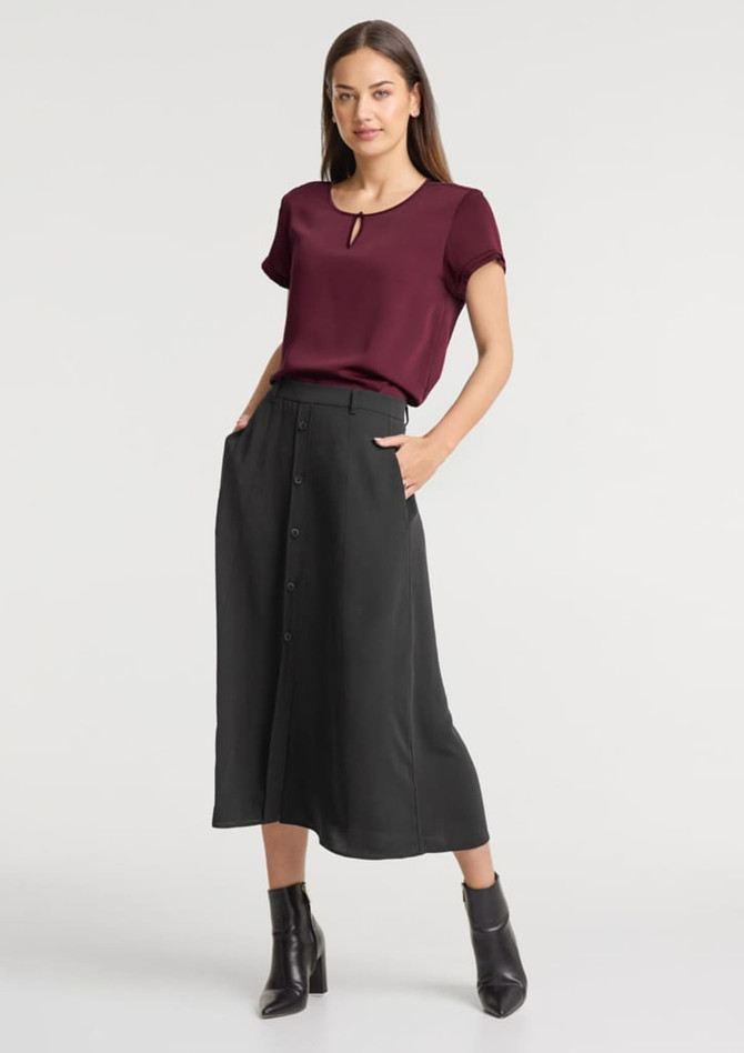 A maroon short sleeve blouse paired with a black skirt. The outfit features a keyhole neckline and side pockets.