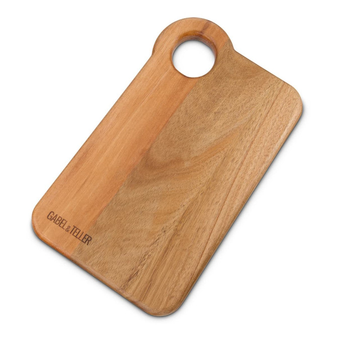 A wooden chopping board with a round handle, featuring a natural finish and a subtle brand logo.
