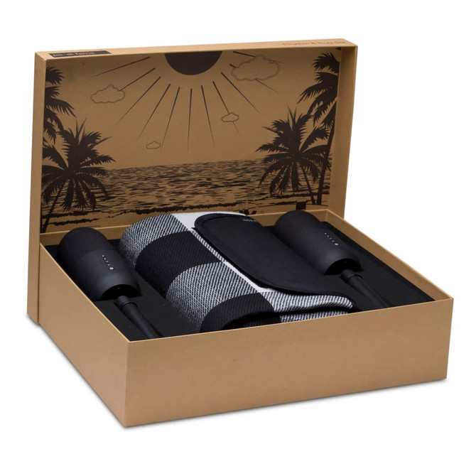A boxed set featuring a striped black and grey rug, two black speakers, and a tropical-themed interior design. A boxed set featuring a striped black and grey rug, two black speakers, and a tropical-themed interior design.