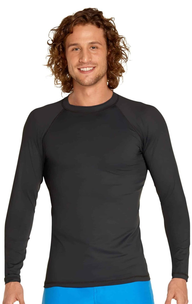 A man wearing a black long sleeve rashie with a fitted design and a logo on the chest.