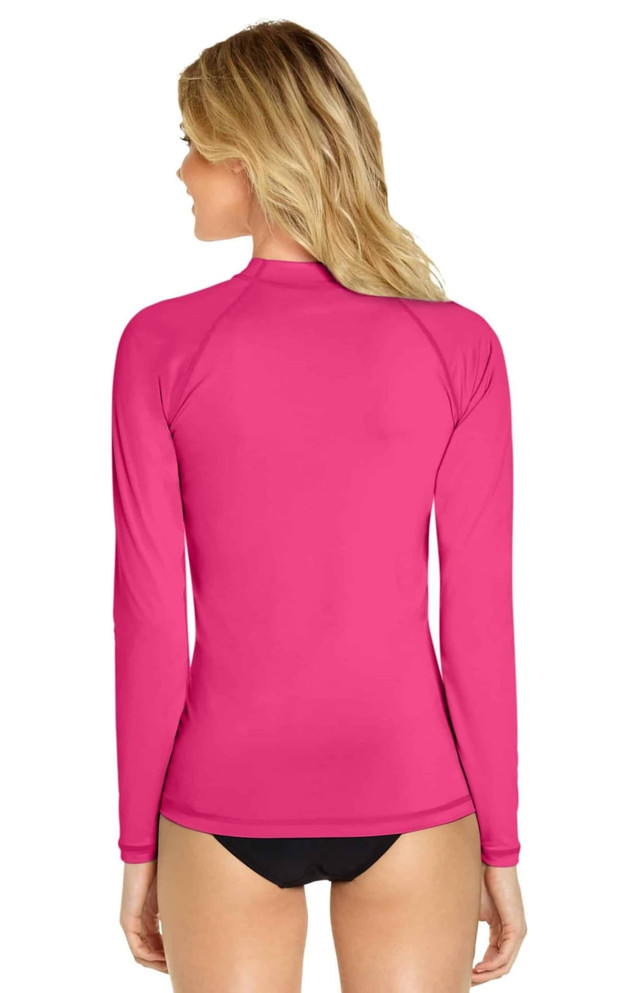 A bright pink long sleeve rashie featuring a high collar and a snug fit, with a logo on the back.