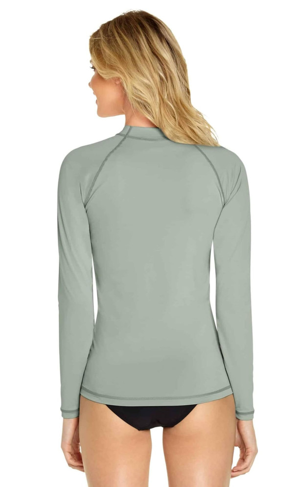 A long sleeve rashie in a muted green colour, featuring a logo on the back.