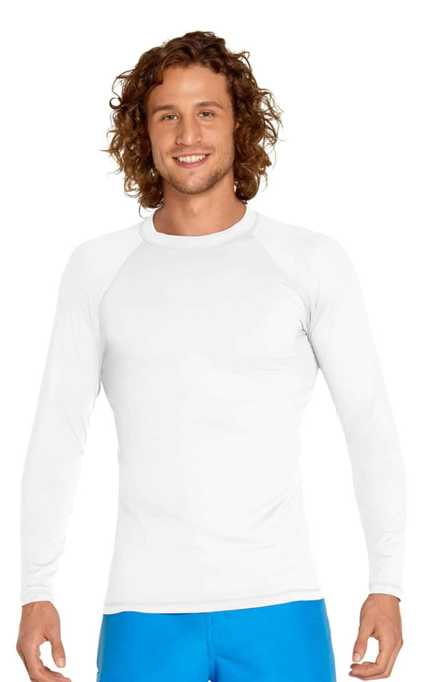 A white long sleeve rashie featuring UPF 50+ protection, worn by a model with curly hair.