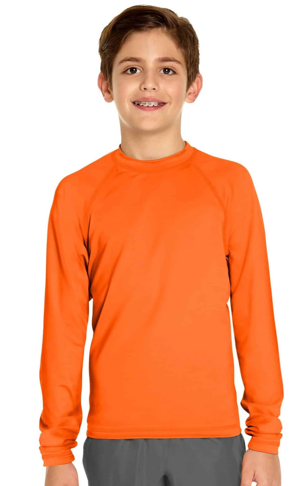 An orange long sleeve rashie designed for youth, featuring a simple, smooth design. It has a logo on the chest.