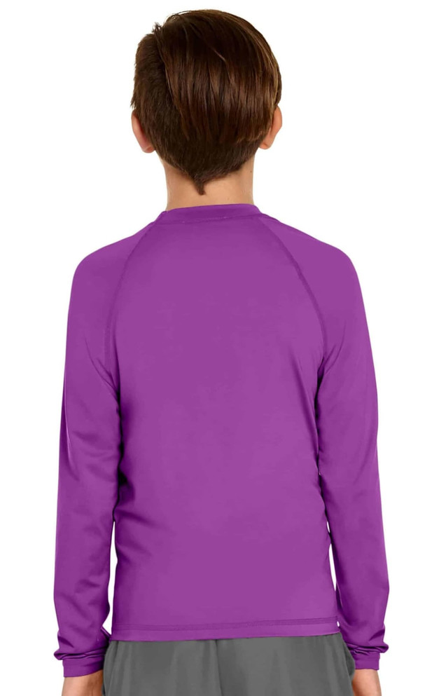 A youth long sleeve rashie in purple with a plain design at the back. It has a logo on the upper section.