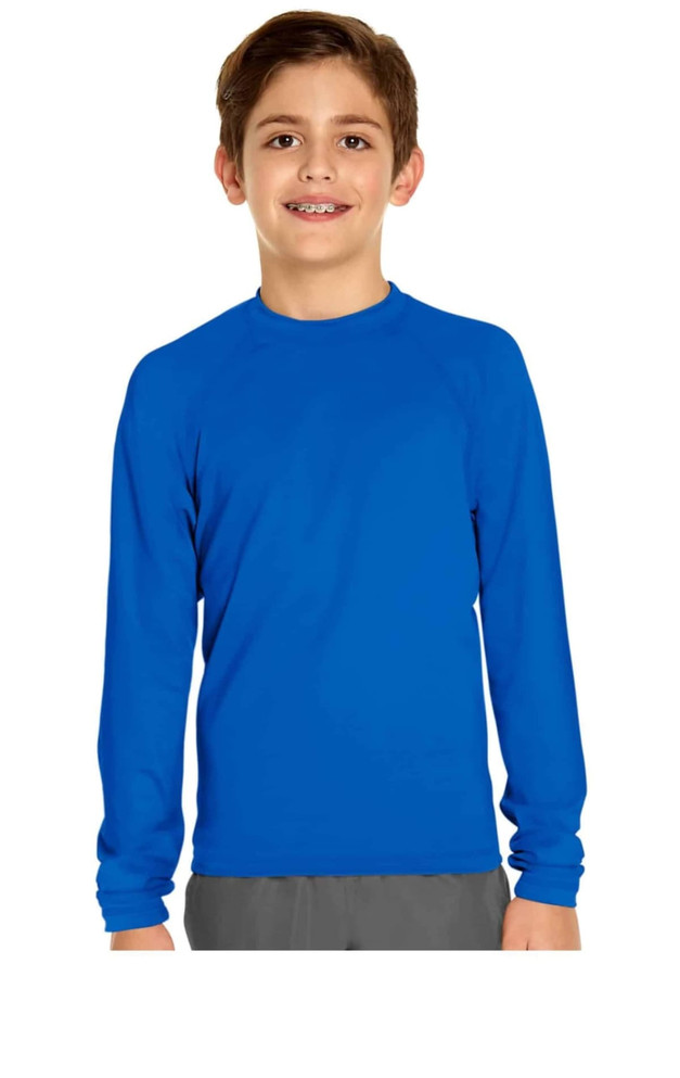 A boy wearing a long sleeve rashie in bright blue, featuring a logo on the garment.