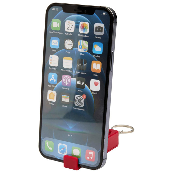 A red recycled plastic phone stand with an attached fidget toy, holding a smartphone displaying various apps.