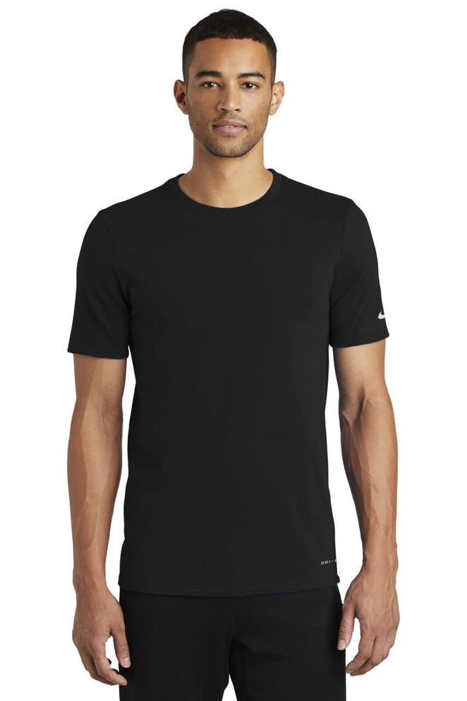 A black Nike Dri-FIT cotton/polyester t-shirt displayed on a model, featuring short sleeves and a logo. A black Nike Dri-FIT cotton/polyester t-shirt displayed on a model, featuring short sleeves and a logo.