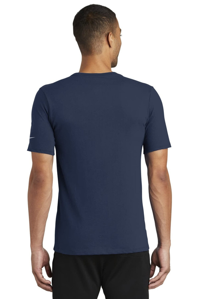 A navy blue Nike Dri-FIT T-shirt featuring a logo, shown from the back on a model. A navy blue Nike Dri-FIT T-shirt featuring a logo, shown from the back on a model.