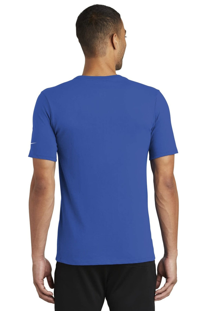 A blue Nike Dri-FIT Cotton/Poly Tee displayed on a model from the back, featuring a logo on the sleeve. A blue Nike Dri-FIT Cotton/Poly Tee displayed on a model from the back, featuring a logo on the sleeve.
