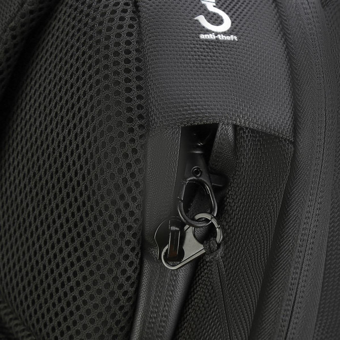 A close-up of a black backpack featuring a zippered pocket and an anti-theft clip.