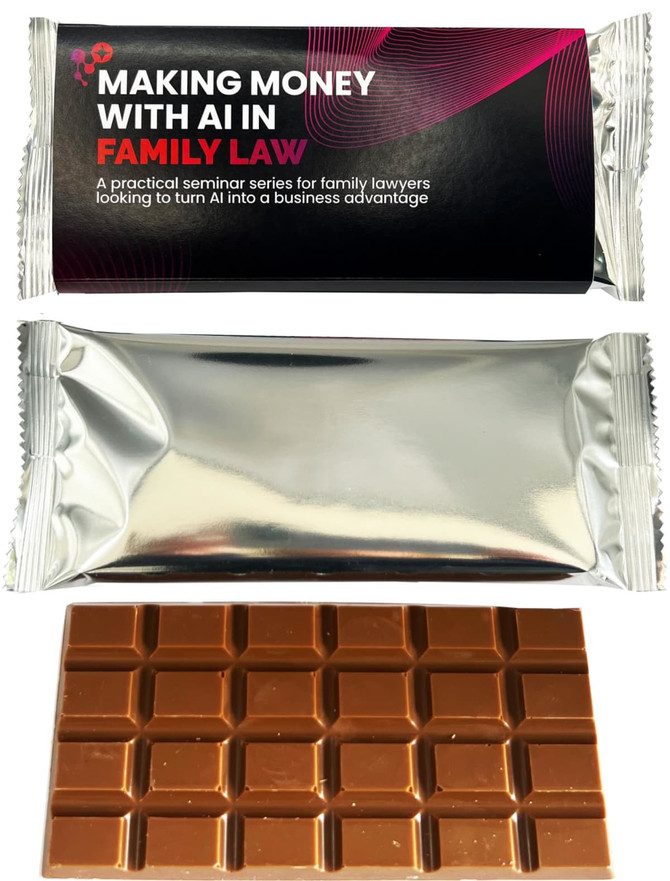 A chocolate bar in a silver wrapper, featuring a dark brown square chocolate pattern. The wrapper has distinctive branding.