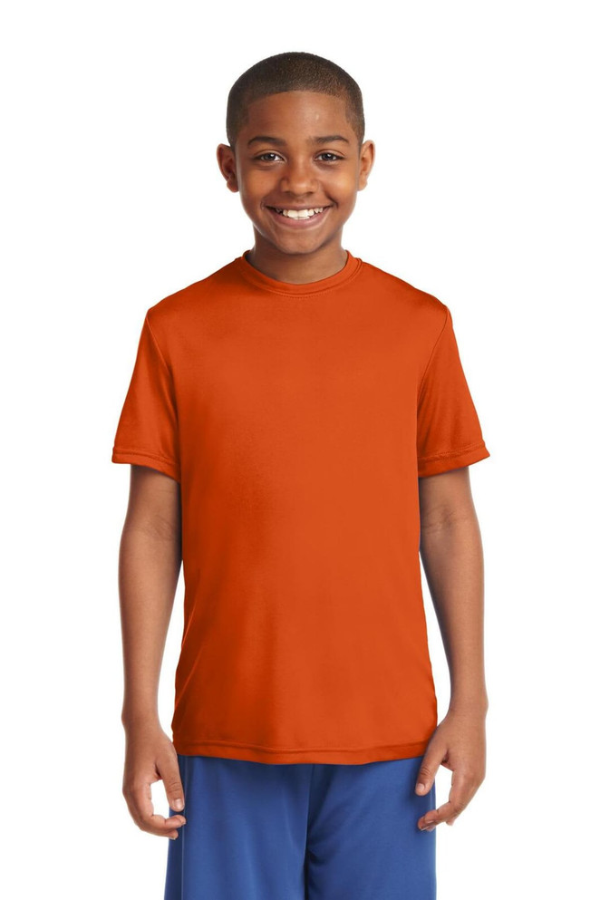A youth in an orange Sport-Tek PosiCharge Competitor Tee stands smiling, wearing blue shorts. The shirt features a logo. A youth in an orange Sport-Tek PosiCharge Competitor Tee stands smiling, wearing blue shorts. The shirt features a logo.