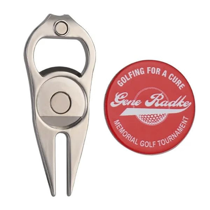 A stainless steel logo divot tool with a bottle opener, accompanied by a red golf ball marker.