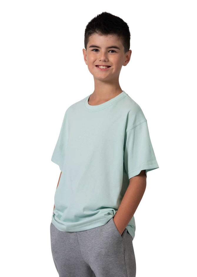 A kid's regular t-shirt in mint green, worn by a smiling boy with his hands in grey pants pockets.