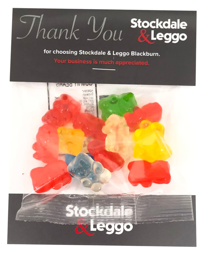 A pack of assorted gummy bears in red, green, yellow, and orange, presented in a branded sleeve.